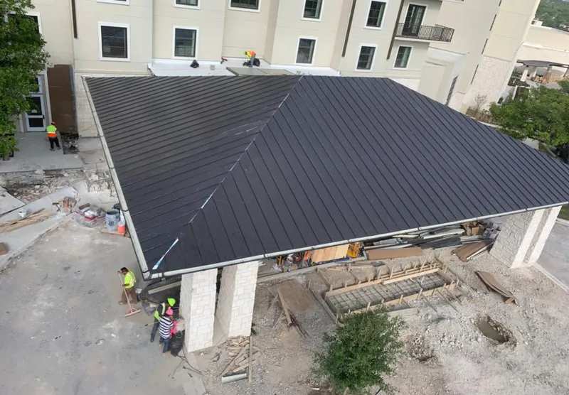 Metal roofing installation team working on a commercial building in Watertown